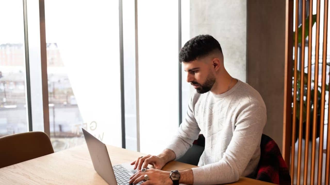A man talking to a therapist via video call from home to process heartbreak and emotions.