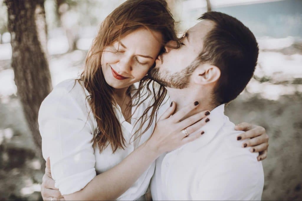 A man kissing a woman’s cheek.