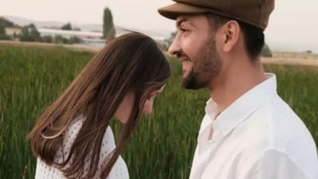 Woman feeling down and giving a half hearted smile to her partner feeling distant