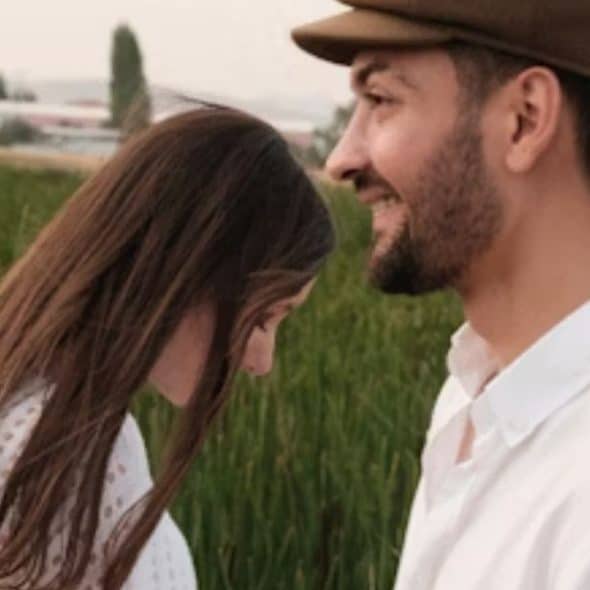 Woman feeling down and giving a half hearted smile to her partner feeling distant
