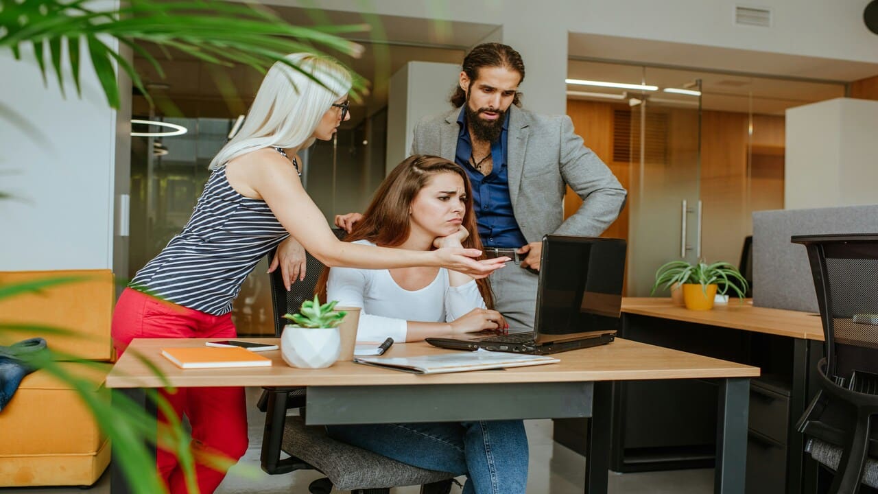 Three colleagues looking serious at work.