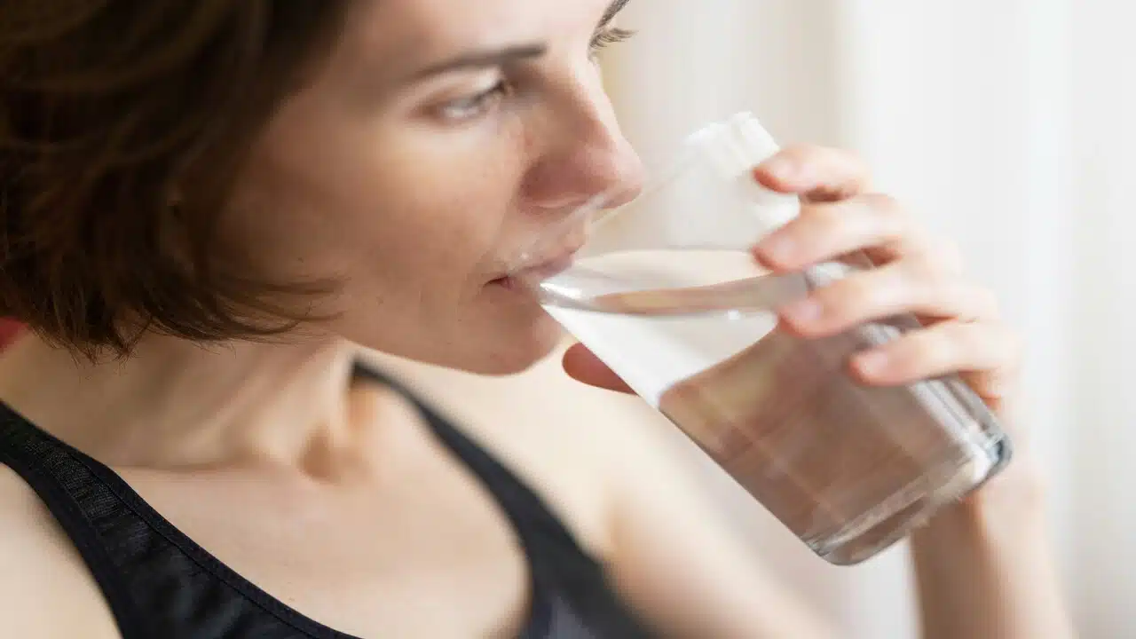 A woman drinking water in the morning.