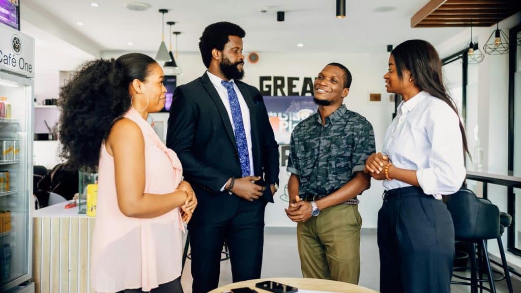 A group of four colleagues chatting in a modern café.