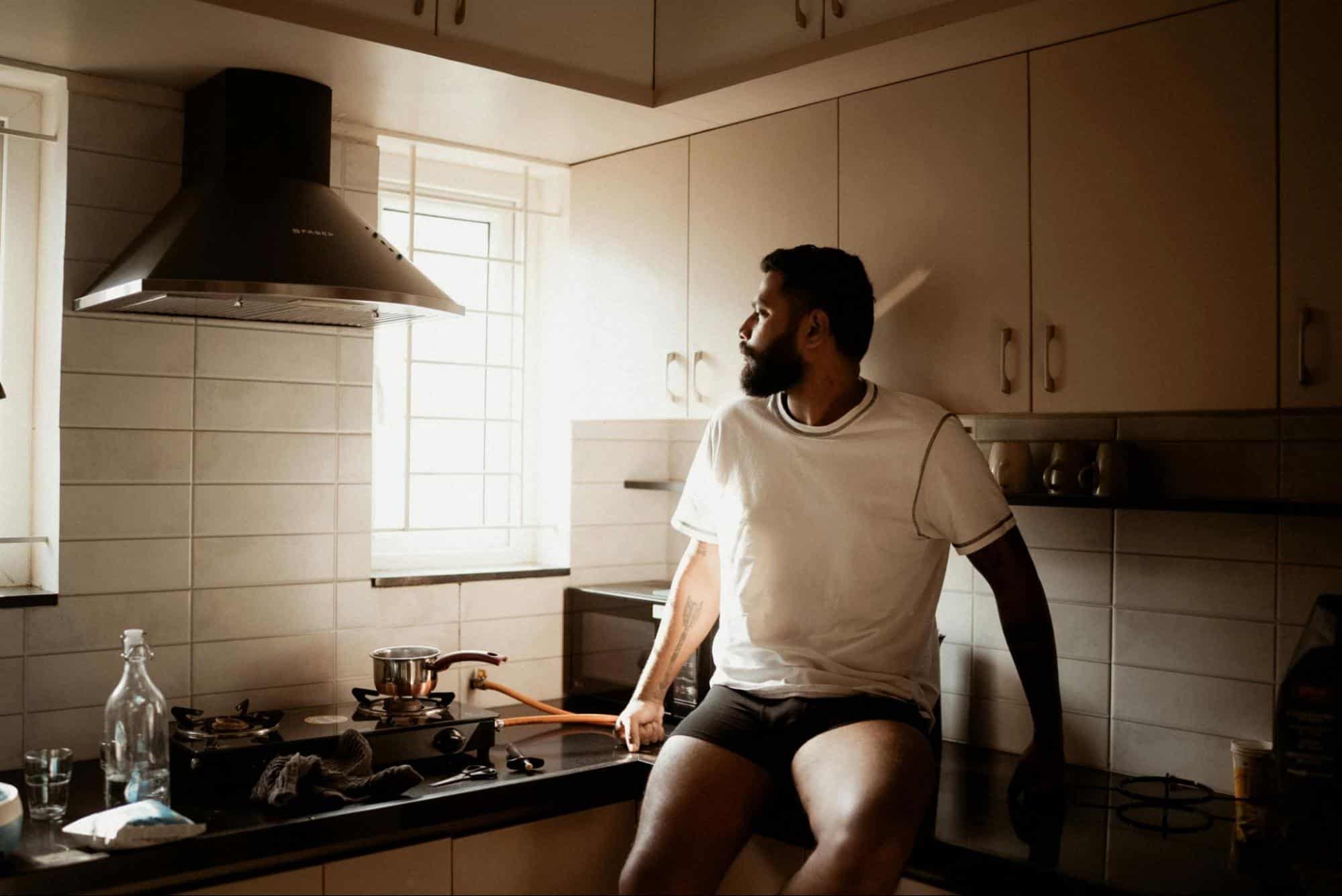 A man sitting at the kitchen top.