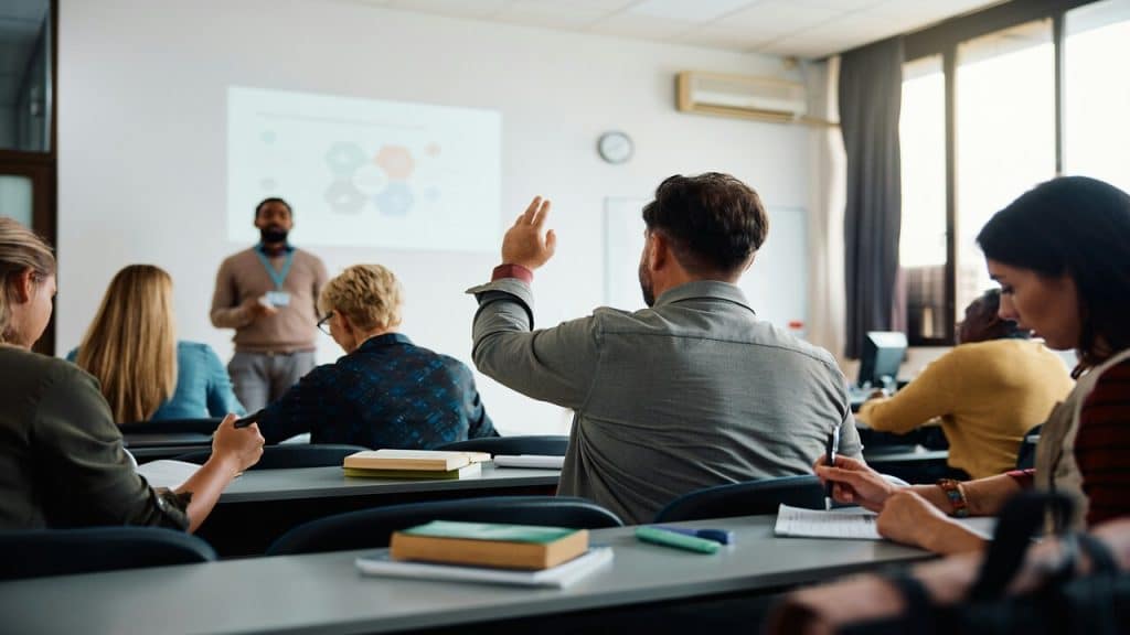 A person raising his hand at a meeting