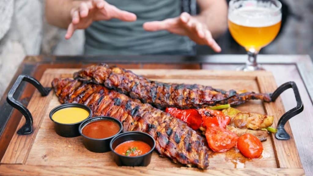 A tray filled with barbecue meat and beer in a restaurant.