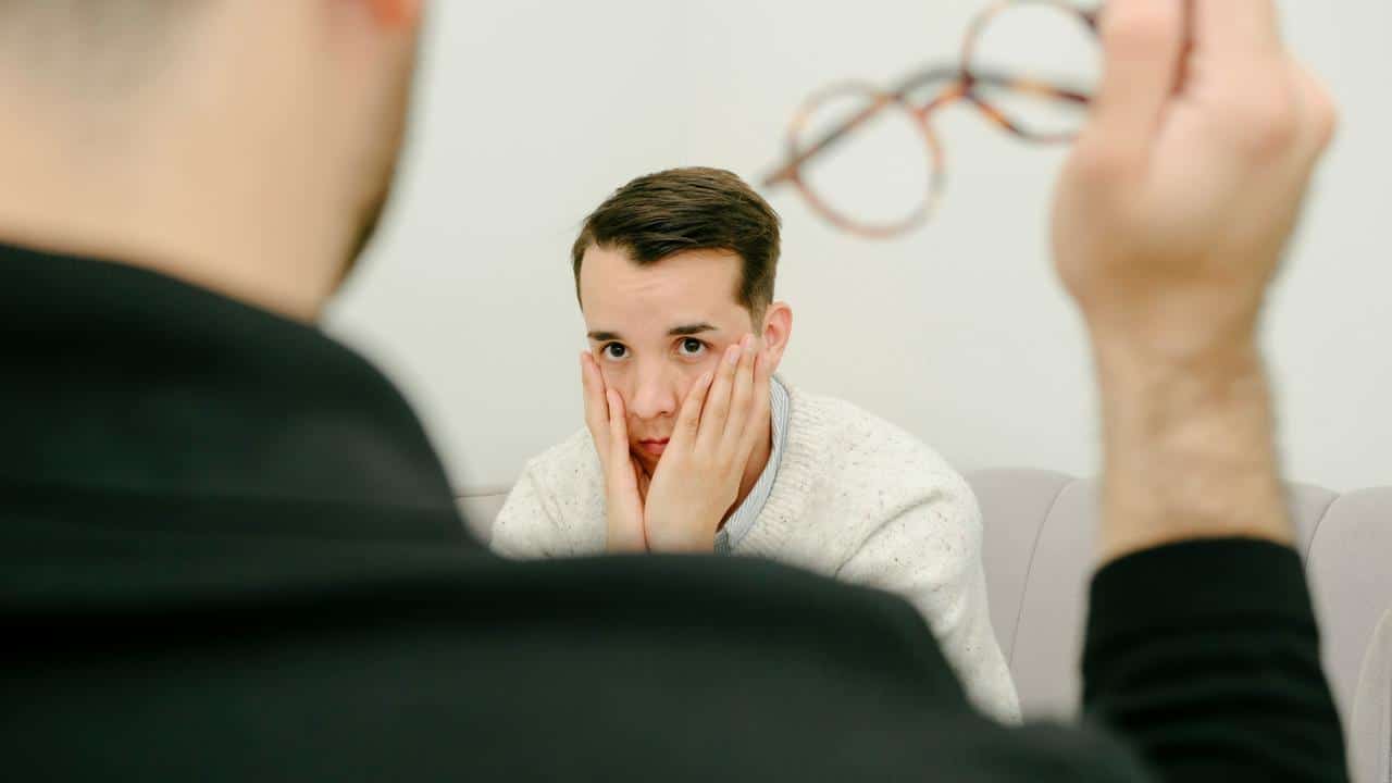 A worried man holding his face.