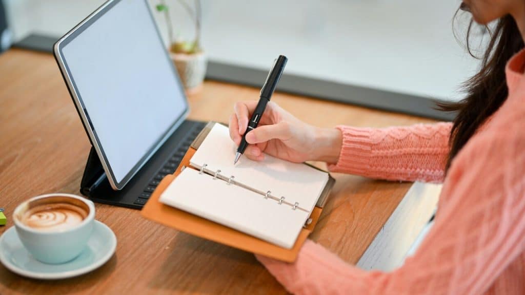 A woman writing on her notebook