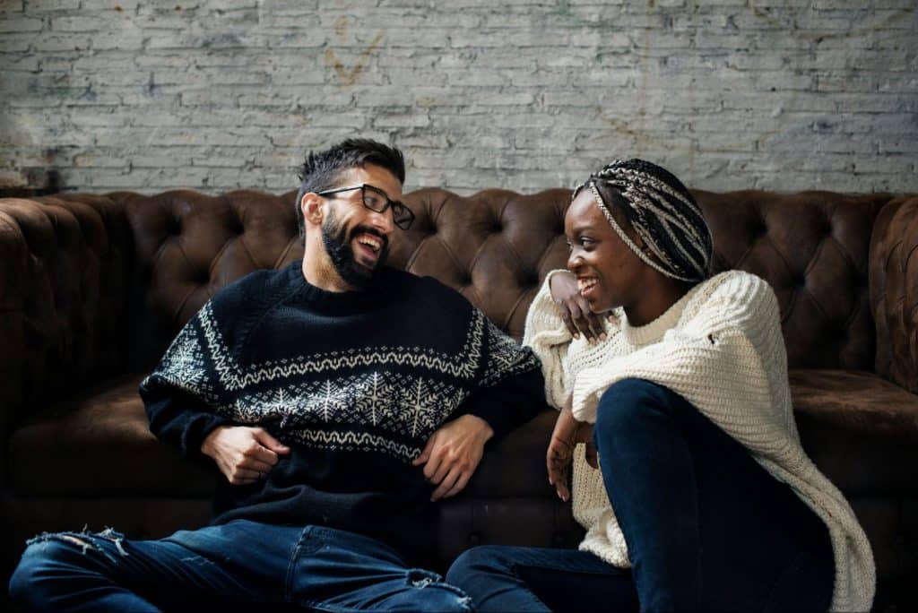 A man and woman talking while sitting on the floor