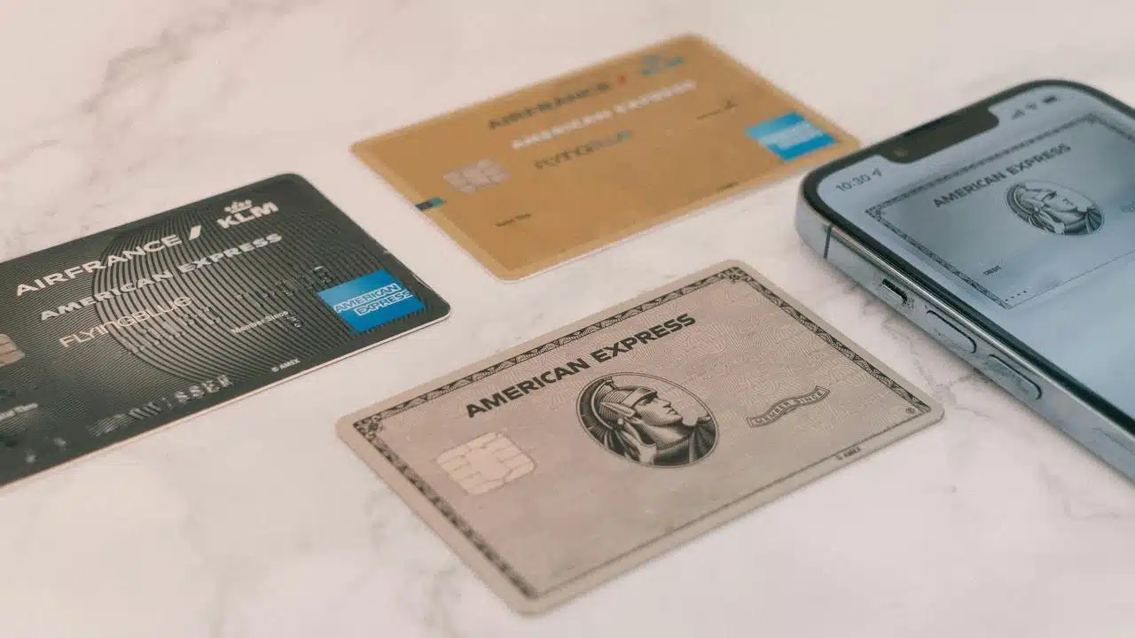 A set of American Express cards alongside a smartphone.