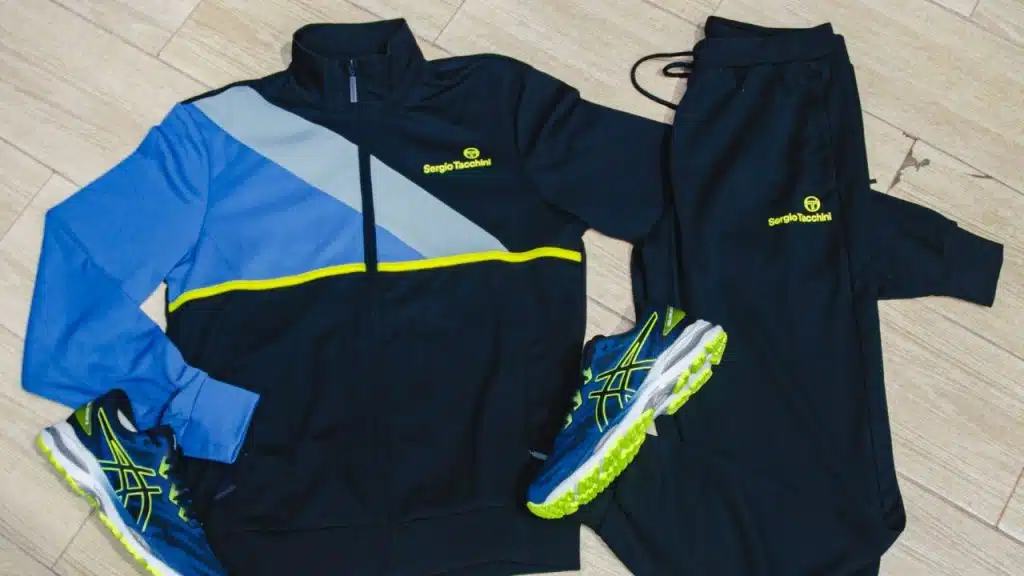 A complete Sergio Tacchini tracksuit, sneakers, and matching sweatpants are laid out.