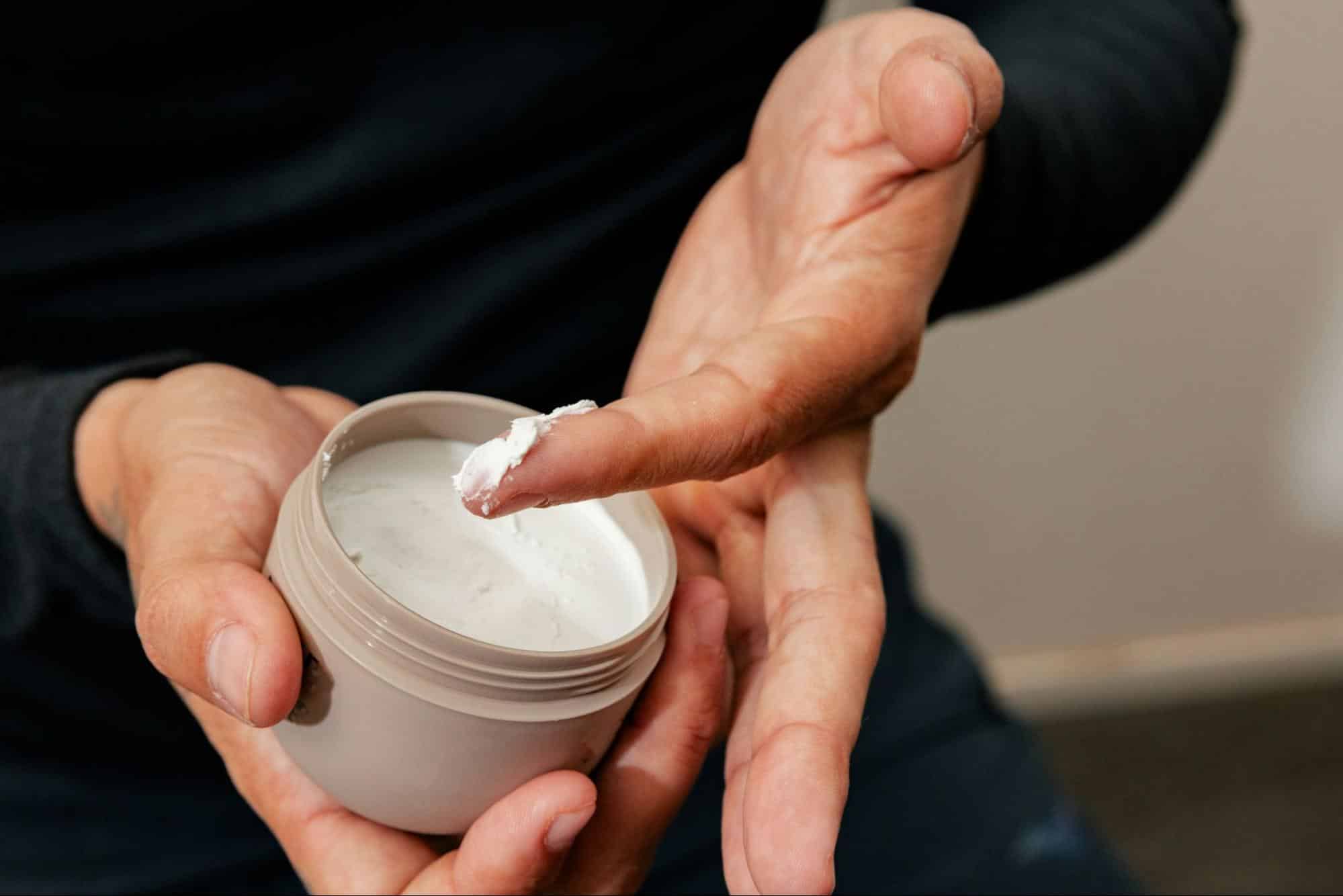 A man holding a cream for moisture.