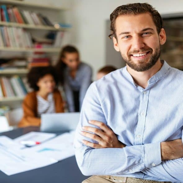 A businessman smiling at the camera.