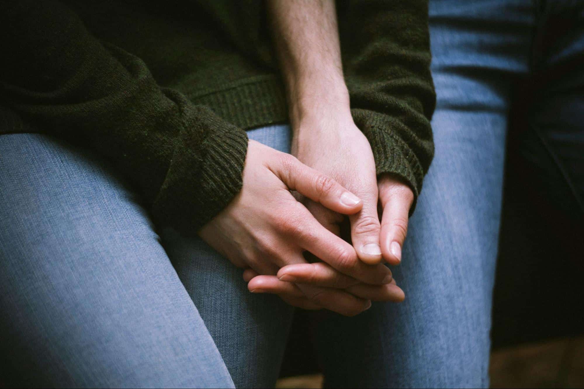 A woman holding a man’s hand.