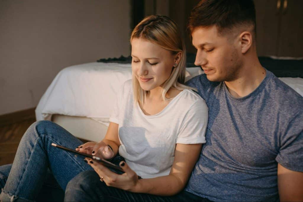 A woman with an awkward smile on her face with her boyfriend