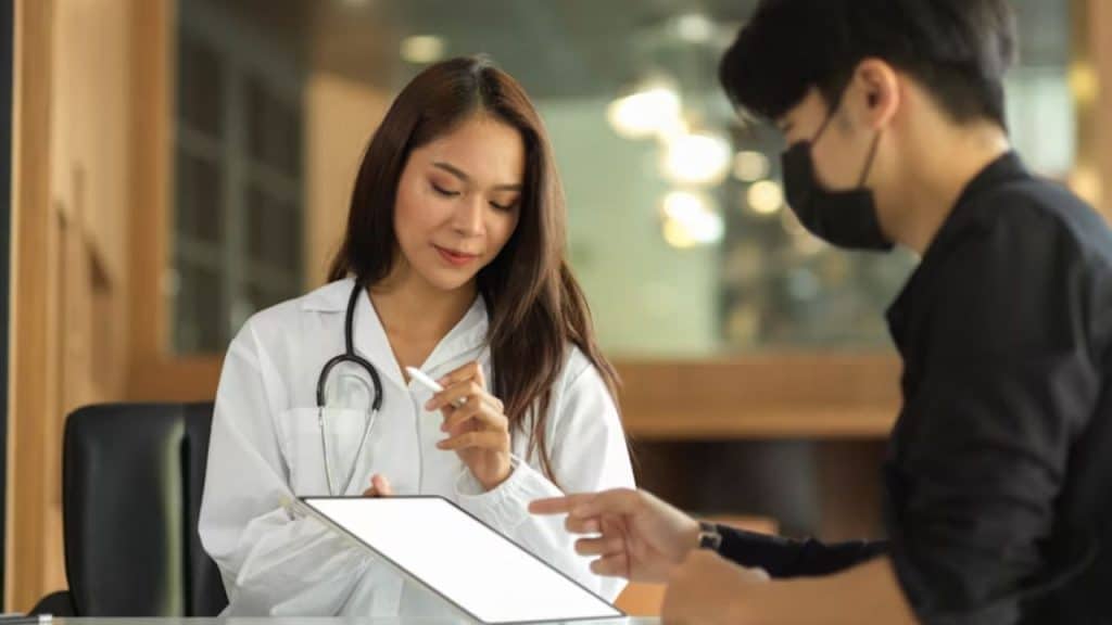 Close up of a doctor reviewing lab results with a male patient.