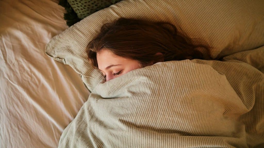 A woman sleeping under a blanket