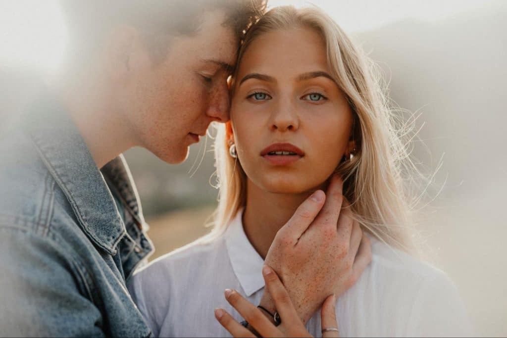 A man reaching a woman’s face.