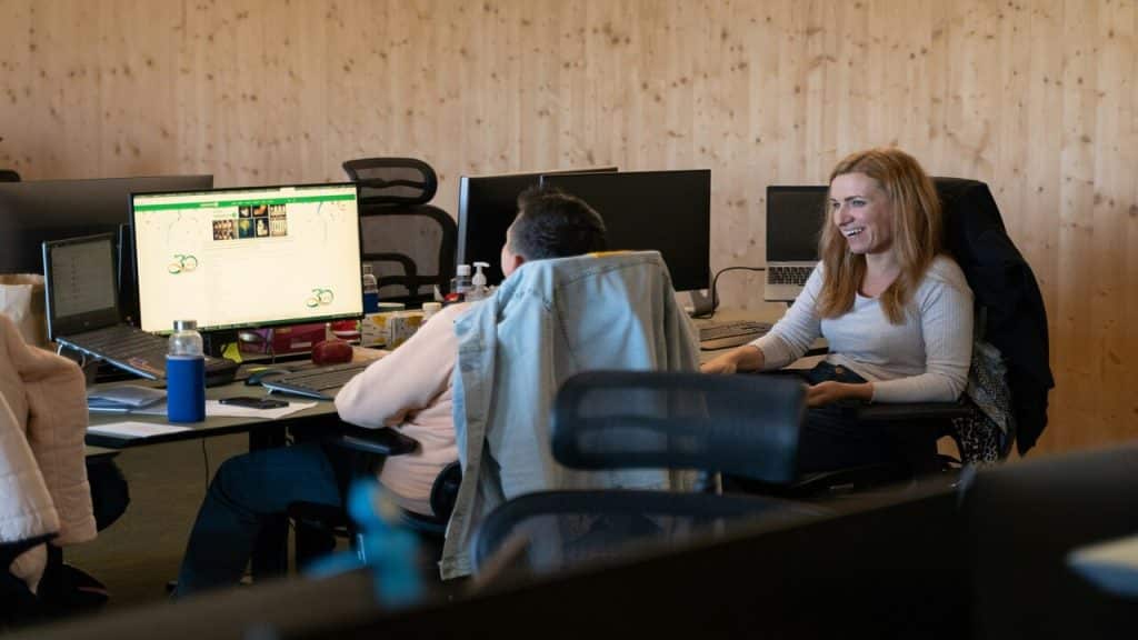 Two colleagues in front of their workspace