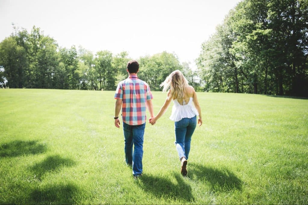 A man and woman walking on the grass 