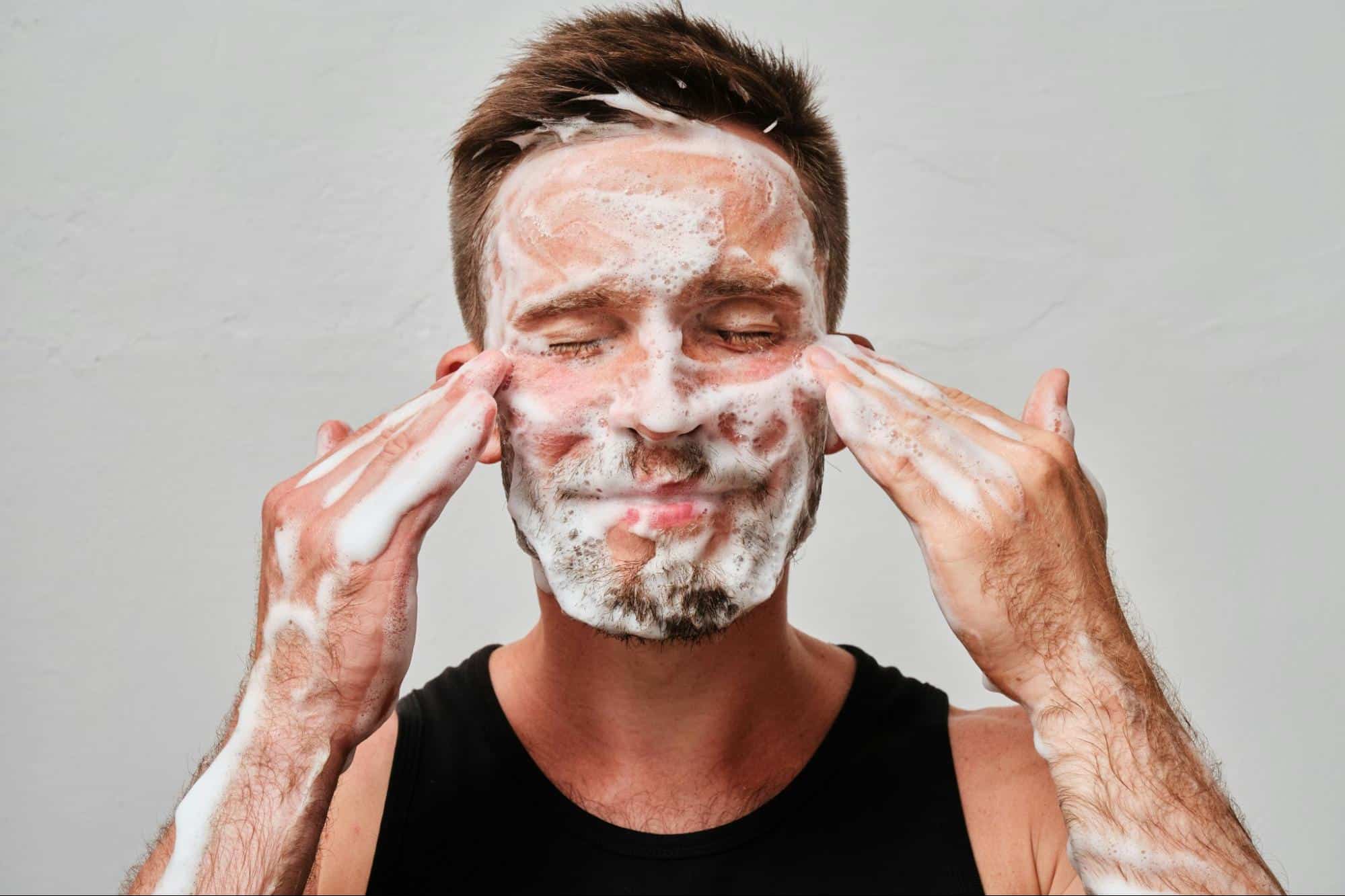 A man using a facial wash.