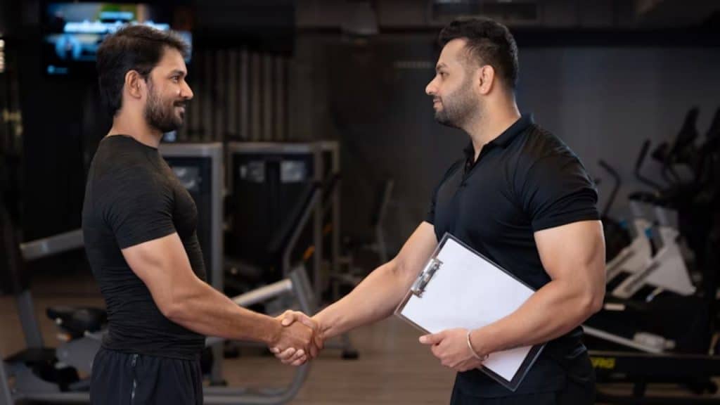 Two men shaking hands or checking in at the gym