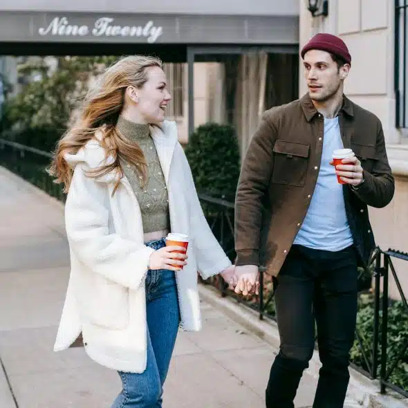 A couple walking on the streets while holding hands.