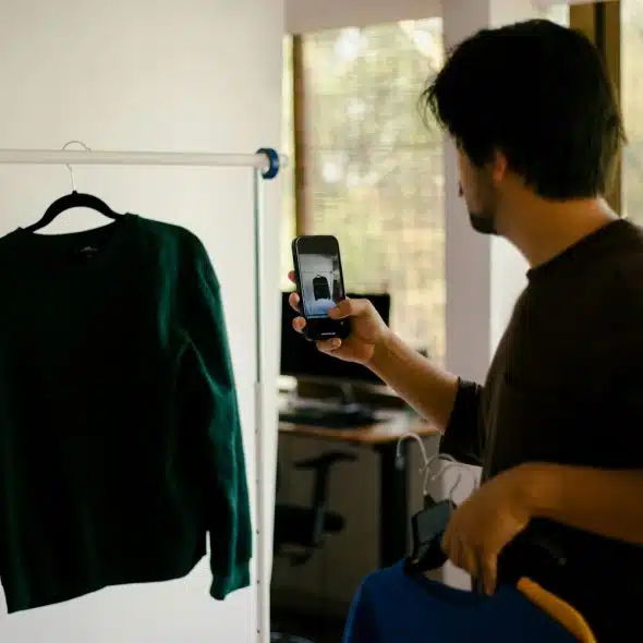 A man taking a picture of a cloth.