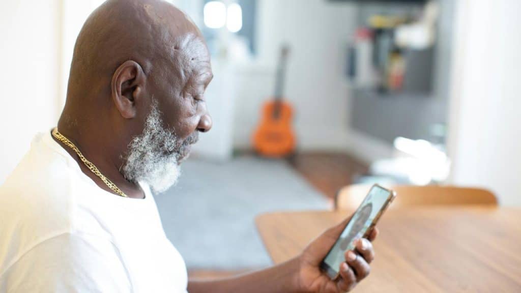 A man looking at his phone during a video call.