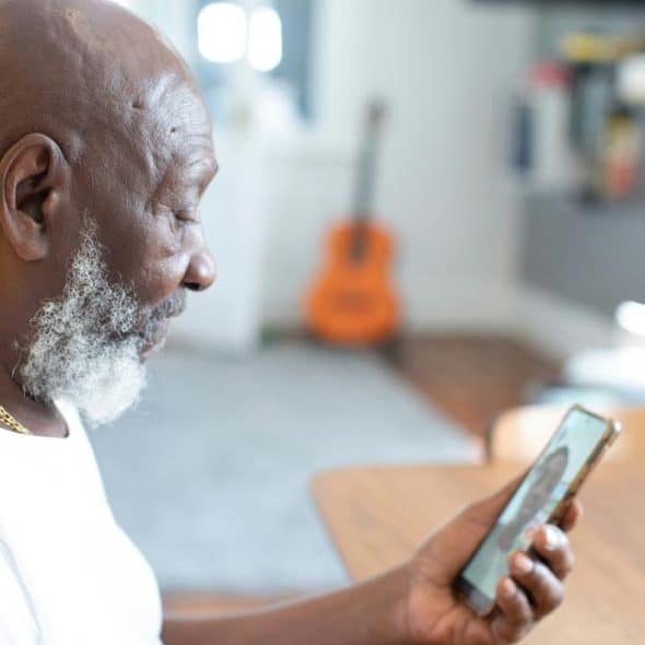 A man looking at his phone during a video call.