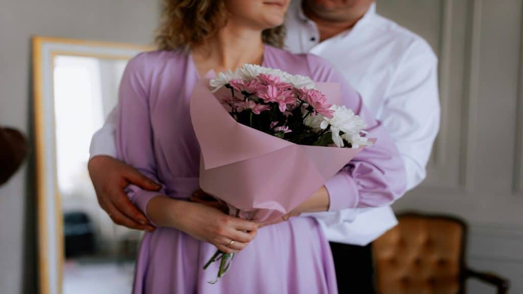 A man giving his partner a bouquet