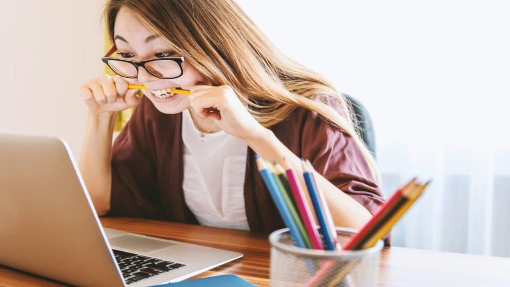 A woman looking stressed in front of her laptop.
