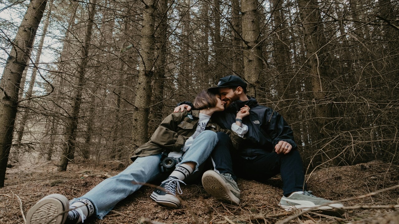 A couple resting in the woods.