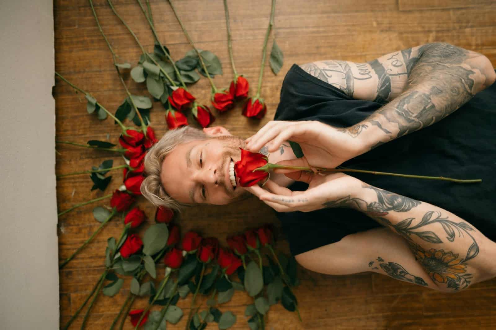A man laying on floor with roses.