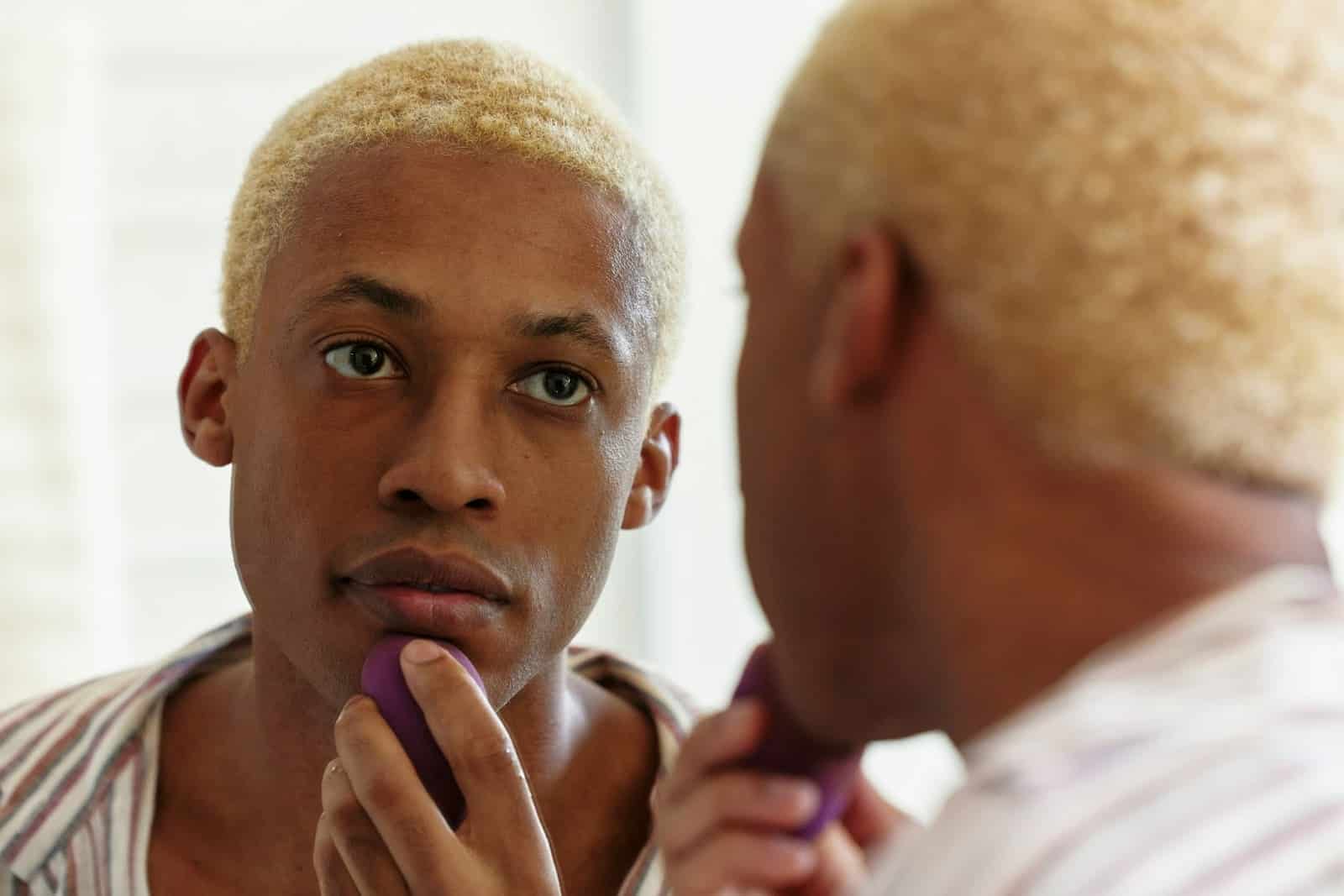 A man looking at the mirror.