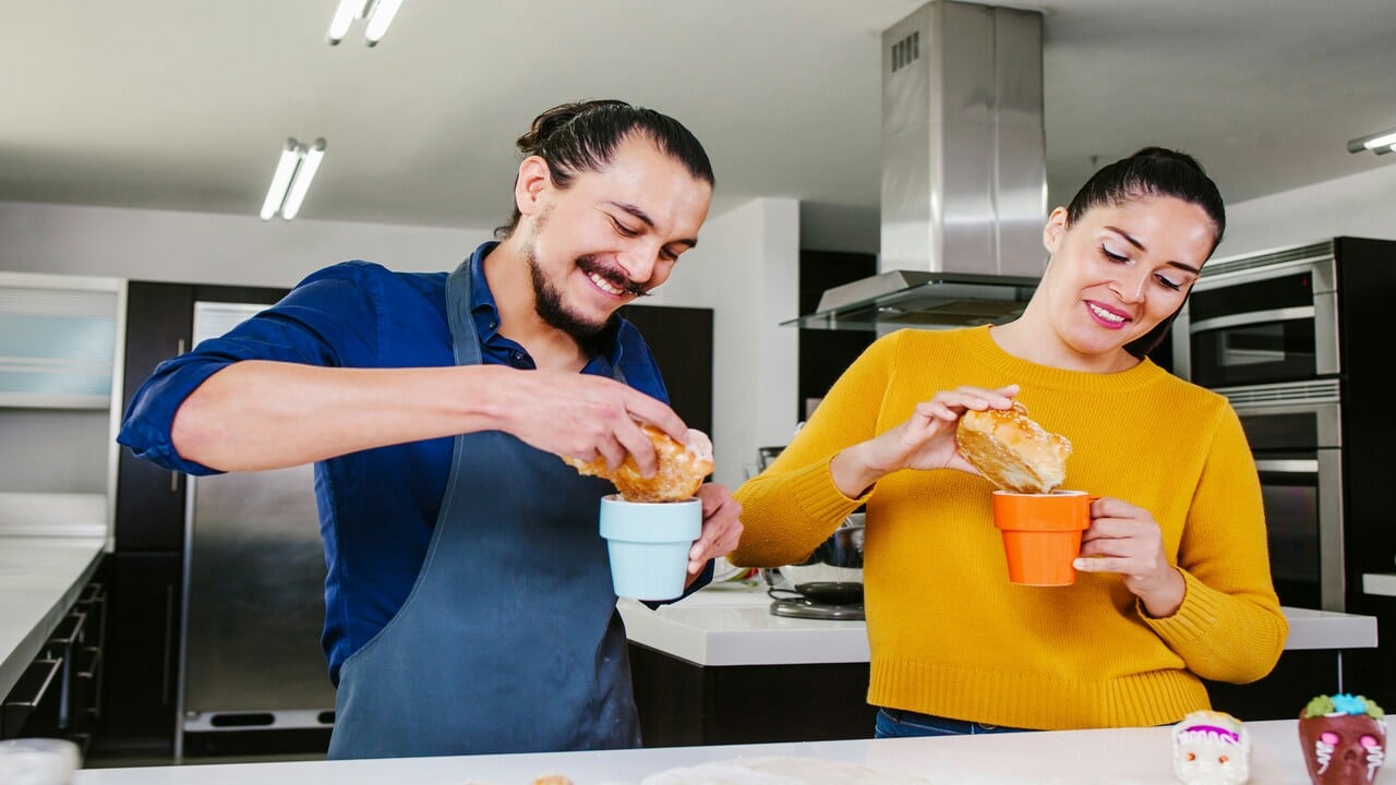 A couple laughing in the kitchen.