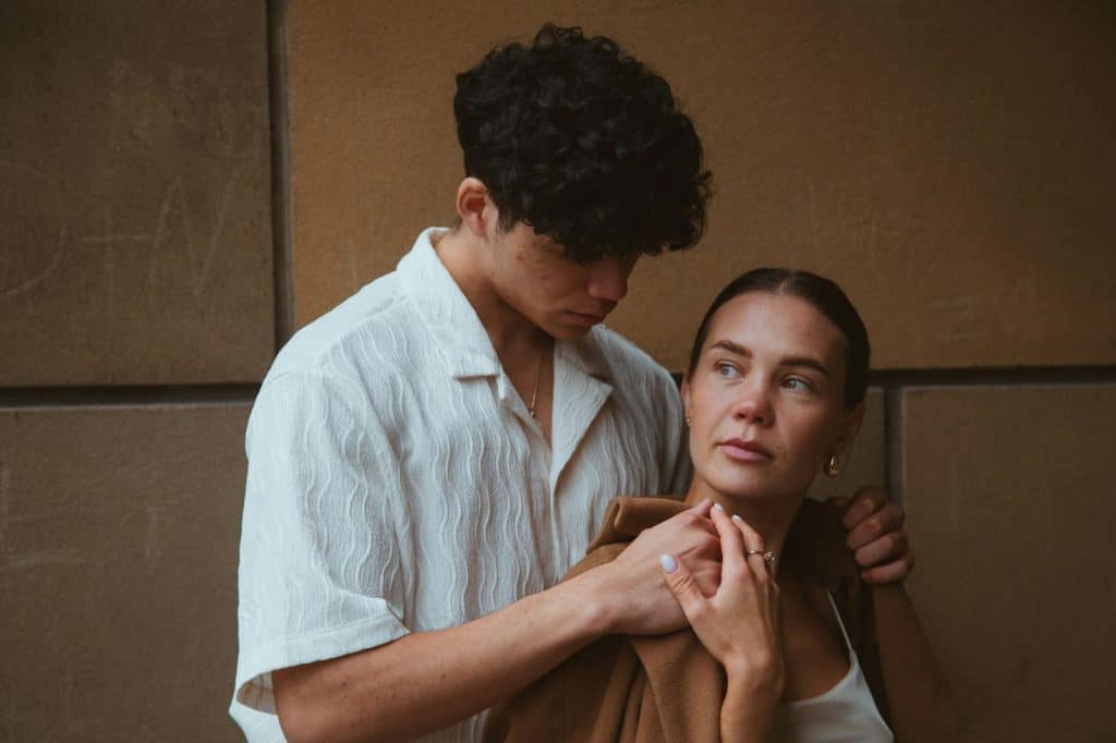A man putting a jacket on a woman’s shoulder