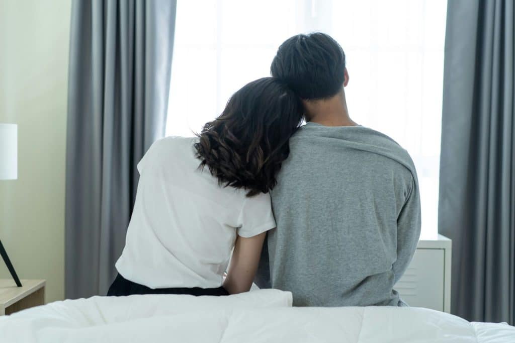 A woman resting her head to a man’s shoulder 