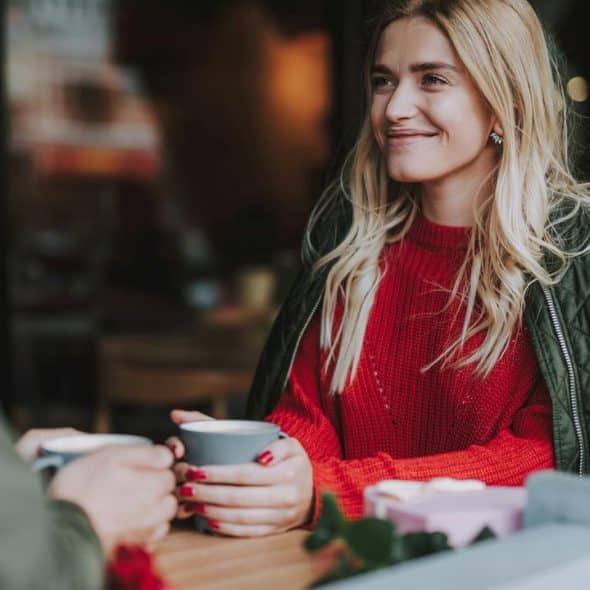 A woman smiling during a coffee date.