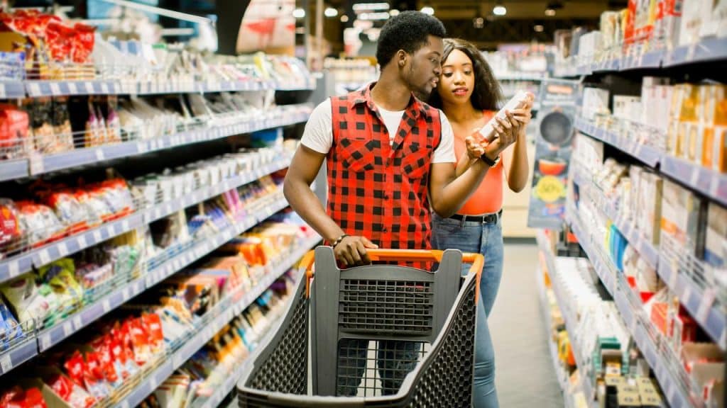 A couple shopping in a grocery store aisle.