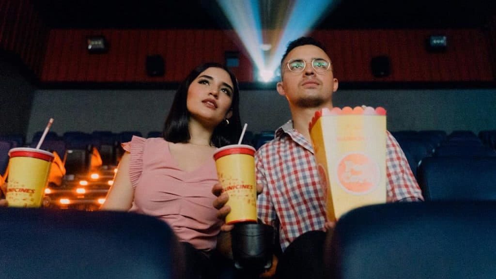 A couple watching a movie in a theater.