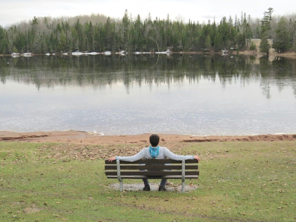 A man sitting on the bench at the lake