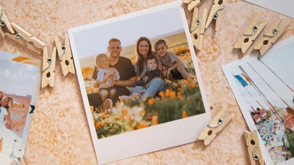 A polaroid photo of a smiling family with three young children sits among clothesline clips.