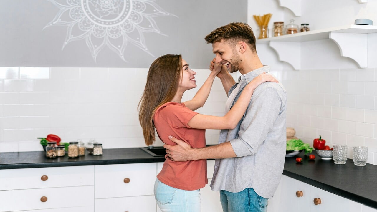 A couple dancing in the kitchen.