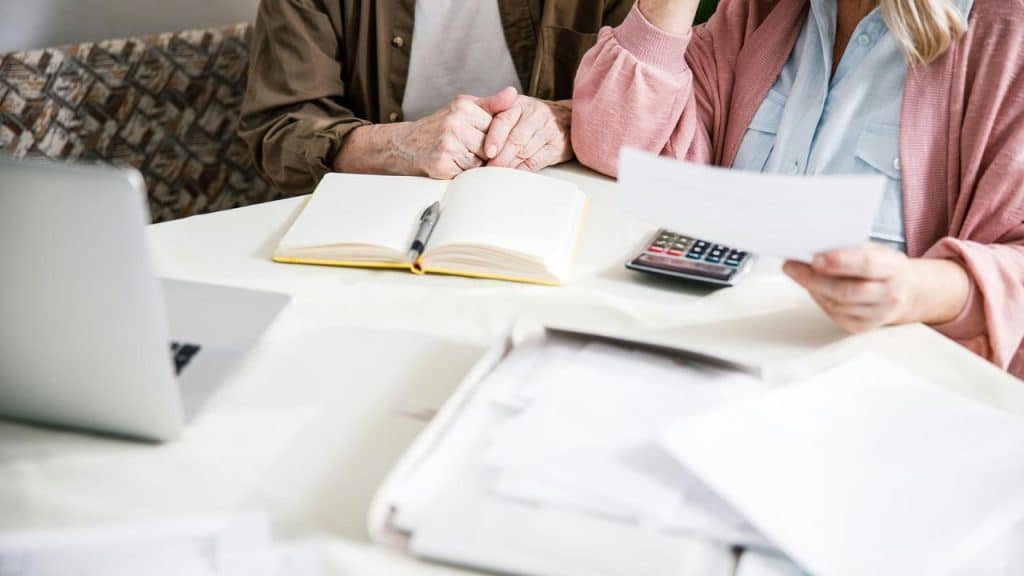 An older couple reviewing finances at a table.