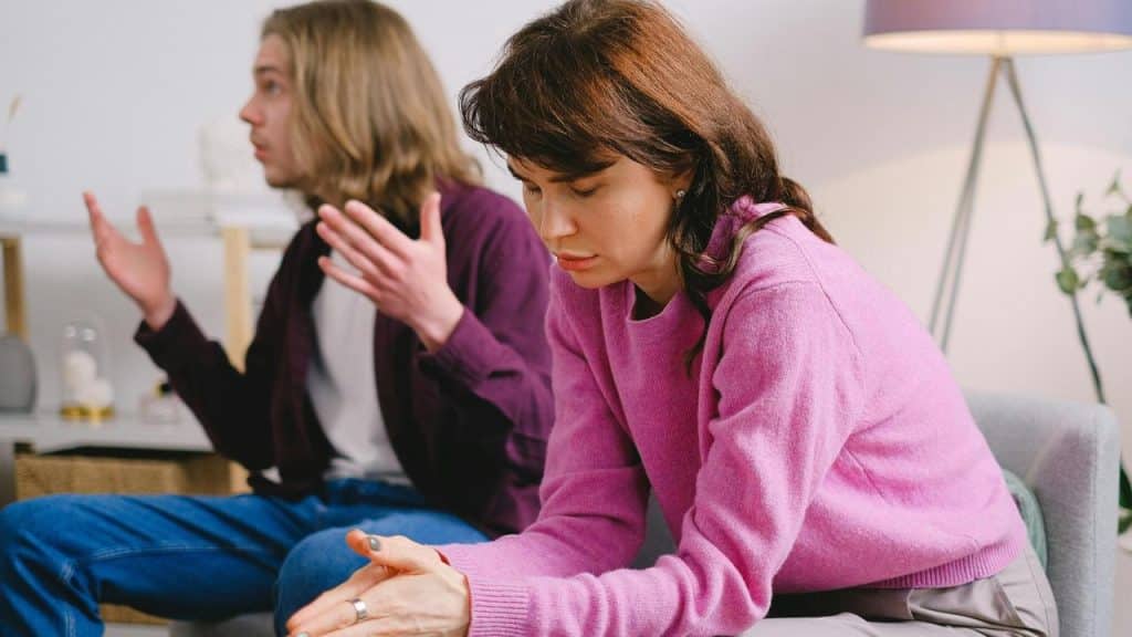 A couple having a tense conversation indoors.