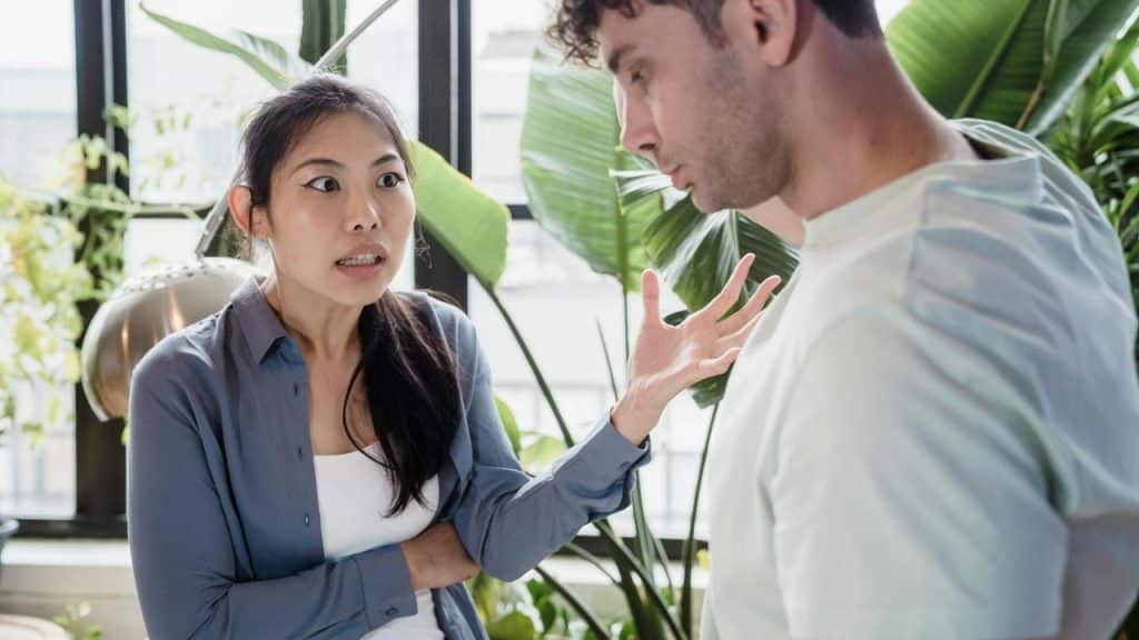 A couple arguing near indoor plants.