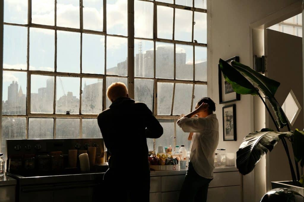 A man and woman in front of window.