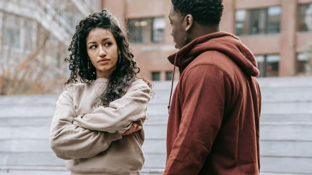 A couple arguing outdoors.