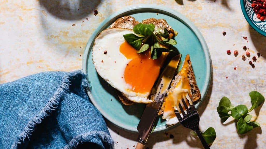 A slice of toast topped with a runny fried egg.